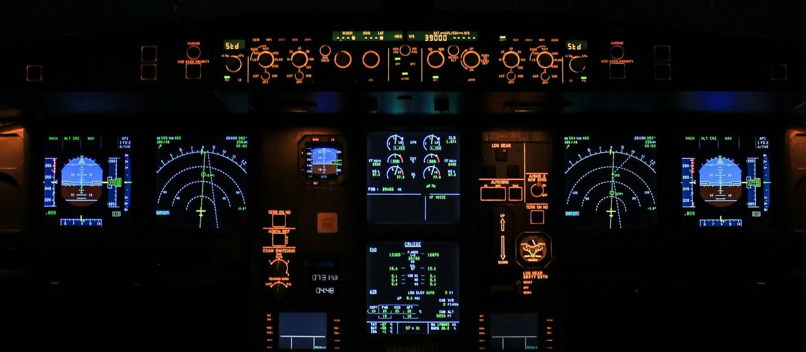 Throttle levers in a dimly lit airliner cockpit